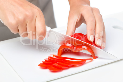 Cook is chopping bell pepper