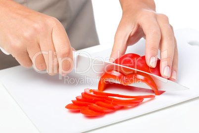 Cook is chopping bell pepper