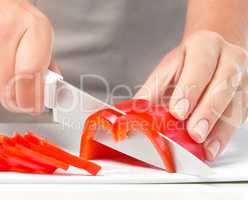 Cook is chopping bell pepper