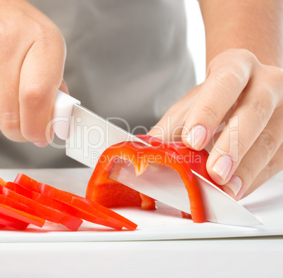 Cook is chopping bell pepper