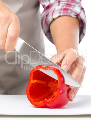 Cook is chopping bell pepper