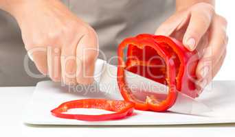 Cook is chopping bell pepper