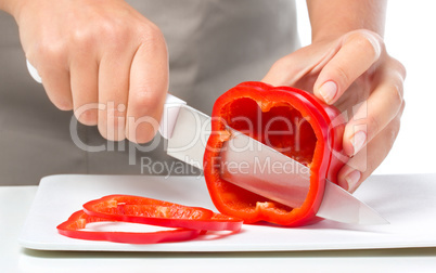 Cook is chopping bell pepper