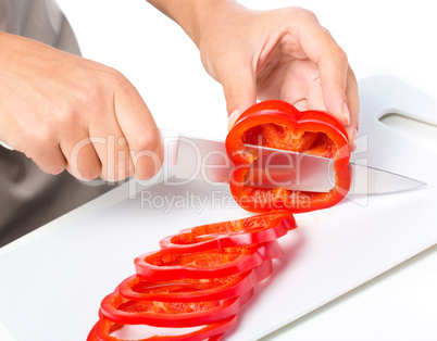 Cook is chopping bell pepper