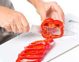 Cook is chopping bell pepper