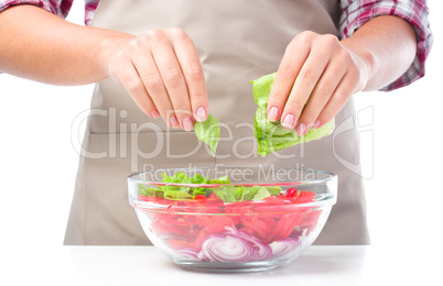 Cook is tearing lettuce while making salad