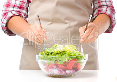 Cook is mixing salad