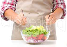 Cook is mixing salad