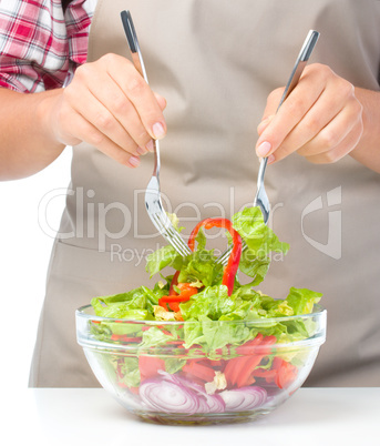 Cook is mixing salad