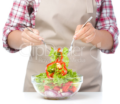 Cook is mixing salad