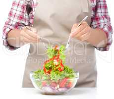 Cook is mixing salad