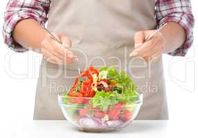 Cook is mixing salad