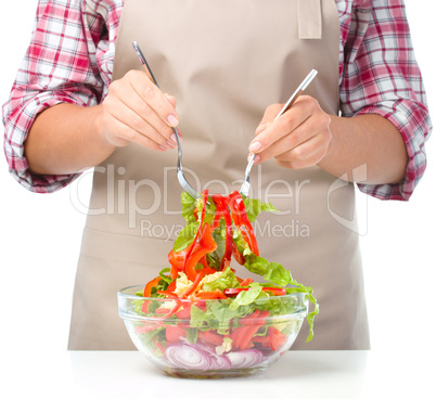 Cook is mixing salad