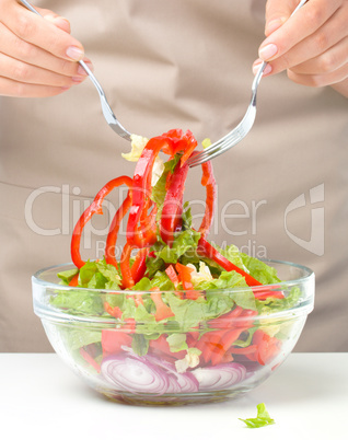 Cook is mixing salad