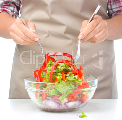 Cook is mixing salad