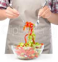 Cook is mixing salad