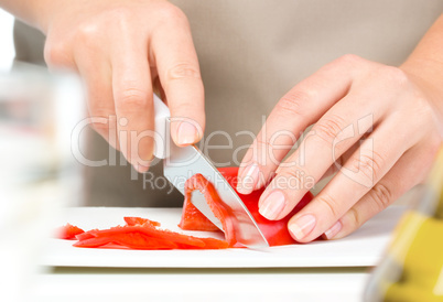 Cook is chopping bell pepper