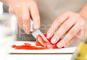 Cook is chopping bell pepper