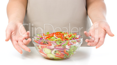 Cook is presenting fresh salad