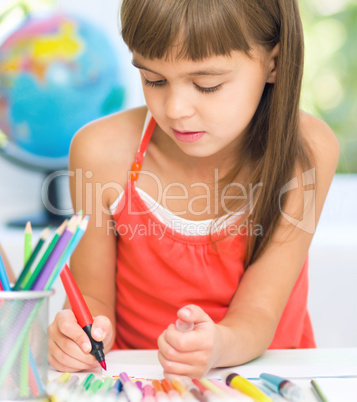 Little girl is drawing using pencils