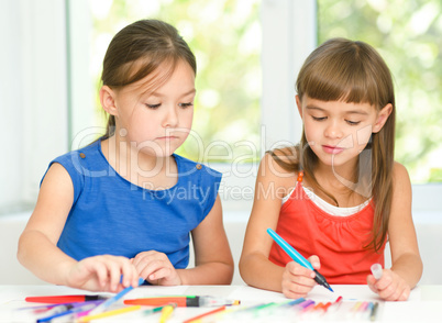 Little girls are drawing using pencils