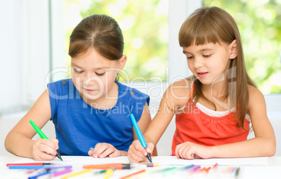 Little girls are drawing using felt- tip pens