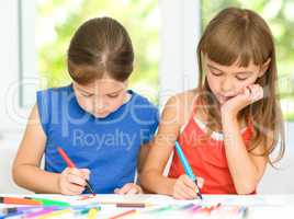 Little girls are drawing using pencils