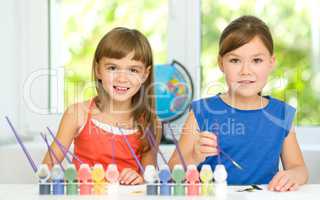 Little girls are painting with gouache