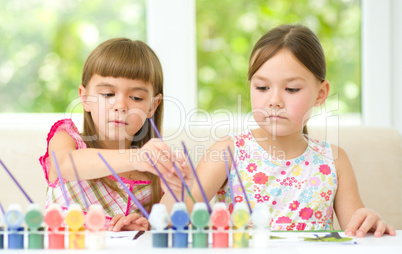 Little girls are painting with gouache