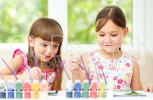Little girls are painting with gouache