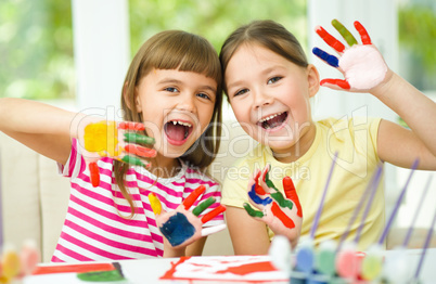 Little girls are painting with gouache