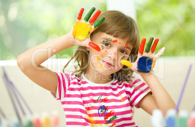 Portrait of a cute girl playing with paints