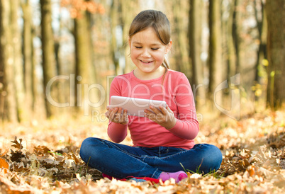 Little girl is reading from tablet