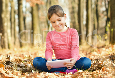 Little girl is reading from tablet