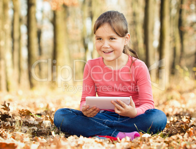 Little girl is reading from tablet