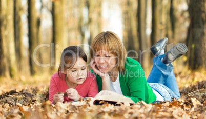 Mother is reading book with her daughter