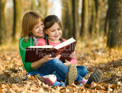 Mother is reading book with her daughter