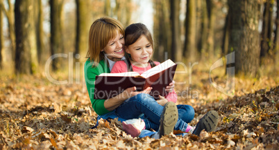 Mother is reading book with her daughter