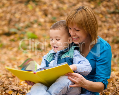 Mother is reading book with her son