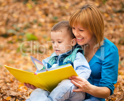 Mother is reading from tablet with her son