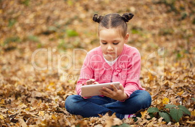 Little girl is reading from tablet