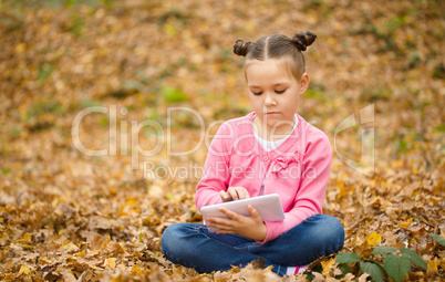 Little girl is reading from tablet