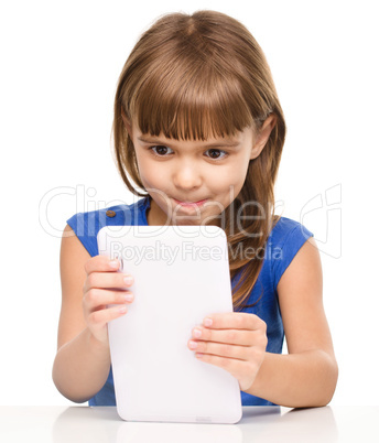 Young cheerful girl is using tablet