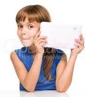 Young cheerful girl is using tablet