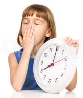 Little girl is holding big clock