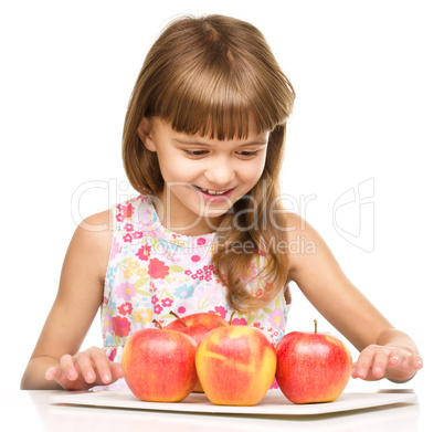 Little girl with red apples