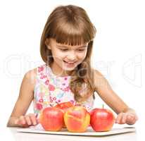 Little girl with red apples