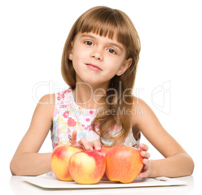 Little girl with red apples