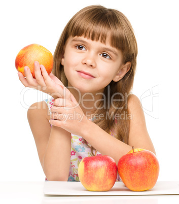 Little girl with red apples