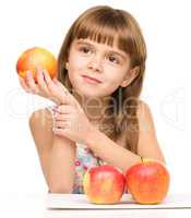 Little girl with red apples